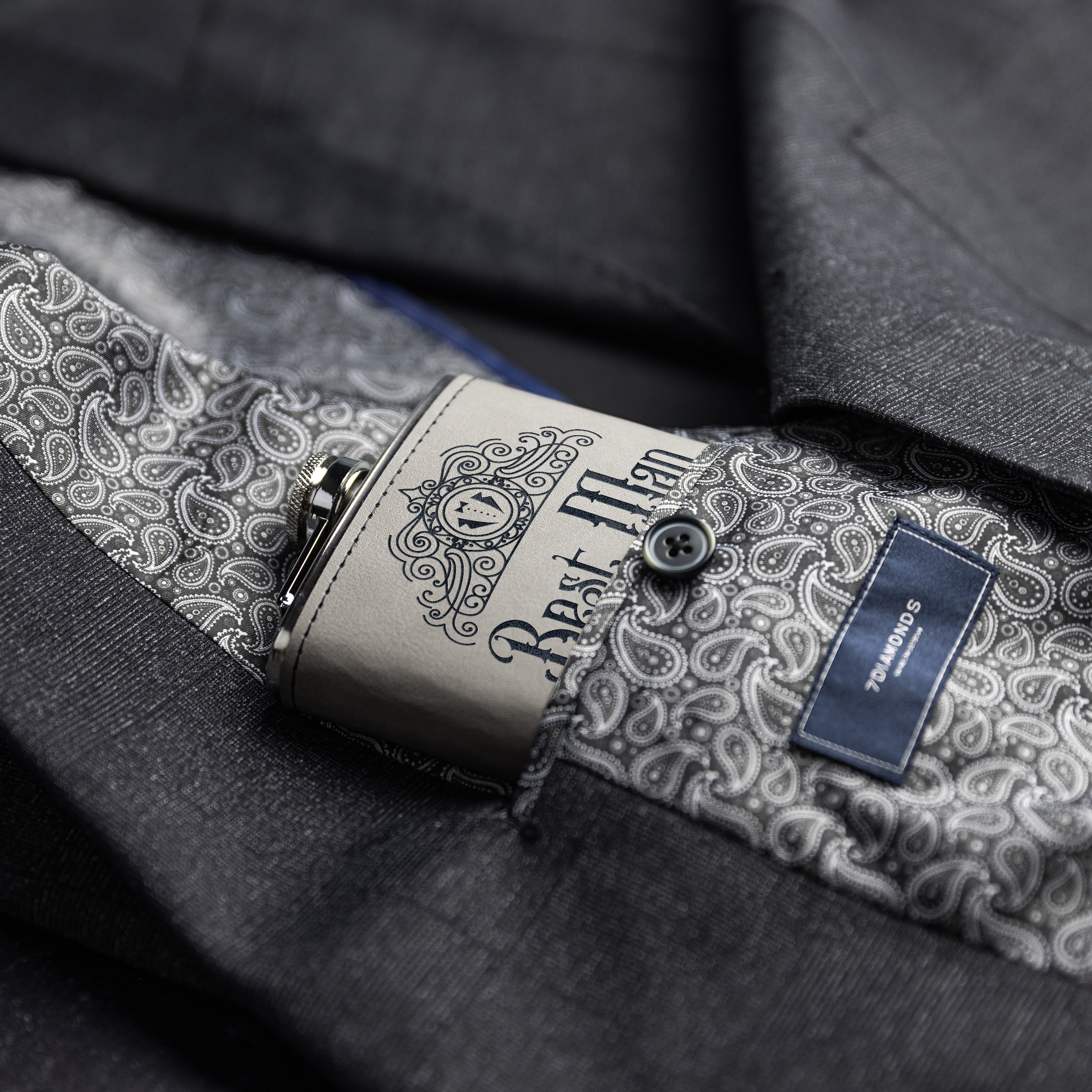 Flasks – Gray leather Flask with laser engraved design lying on dark fabric – Lifestyle view